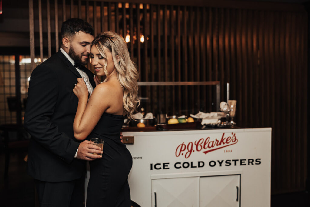 Danielle and Dominic share intimate moments in the stylish setting of PJ Clarkes, capturing the essence of their love in this bar engagement photo.