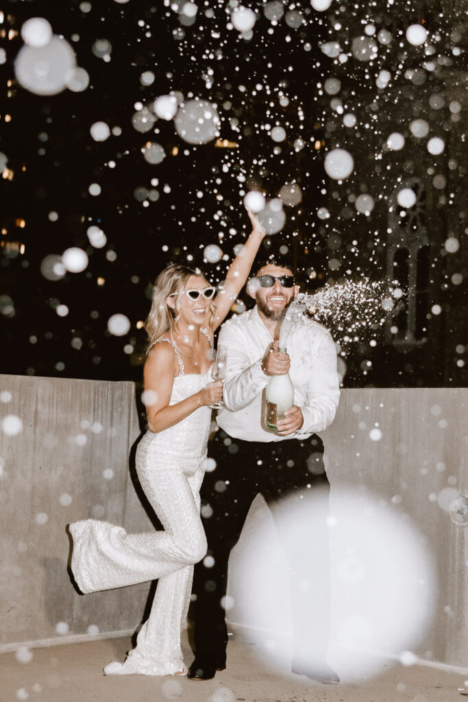 Flash photography adds a touch of magic to Danielle and Dominic's rooftop celebration, capturing the joy of champagne showers in this Philadelphia engagement moment.