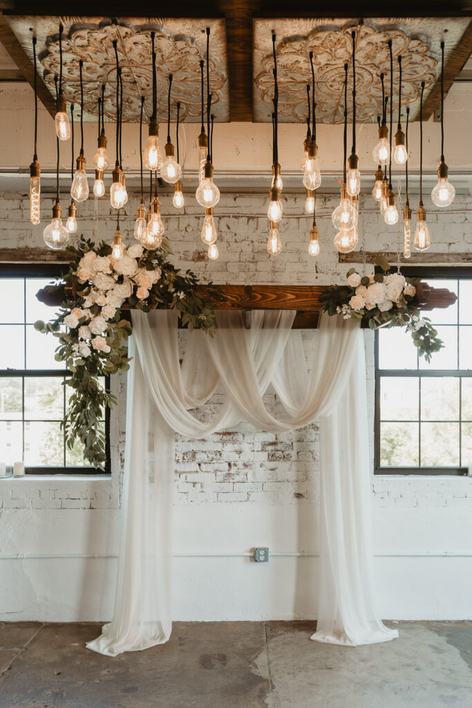 Ceremony setup with edison bulbs and draped fabric at the industrial chic wedding venue of casablanca in philadelphia