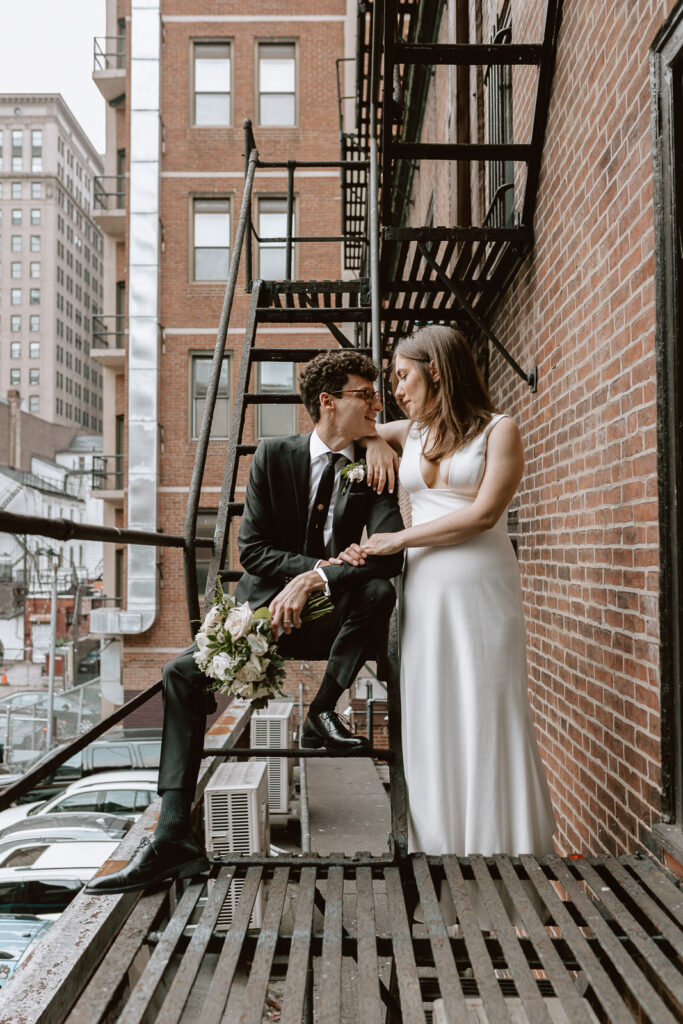 bride and groom embracing outside of guild house hotel philadelphia on fire escape