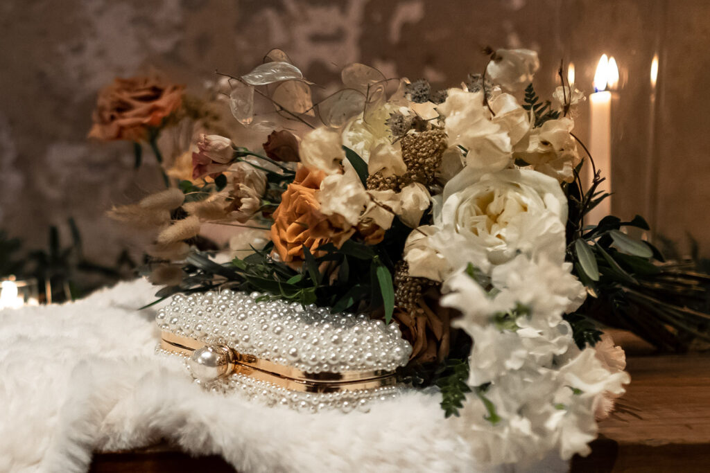 florals and brides clutch covered in pearls at a unique philadelphia wedding venue