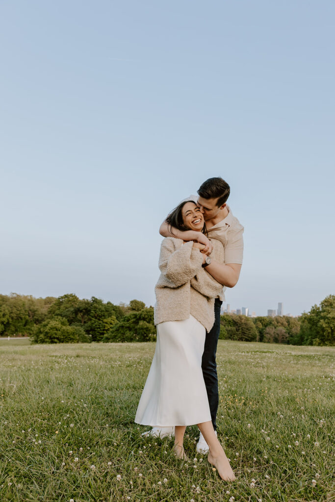 guy hugging girl from behind at belmont plateau for their engagement photos in philadelphia