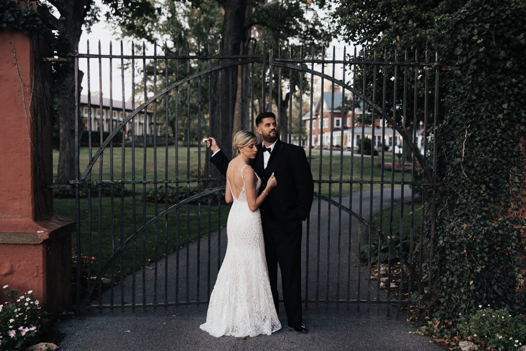 bride and groom embracing outside the gates at their Cameron Estate Inn Wedding