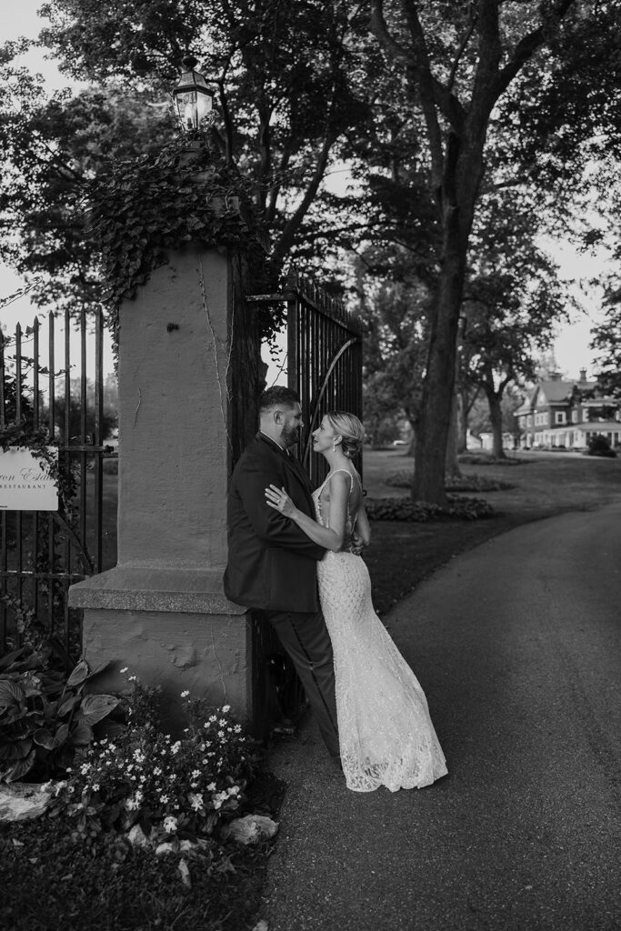 bride and groom posing at the gates at their Cameron Estate Inn Wedding
