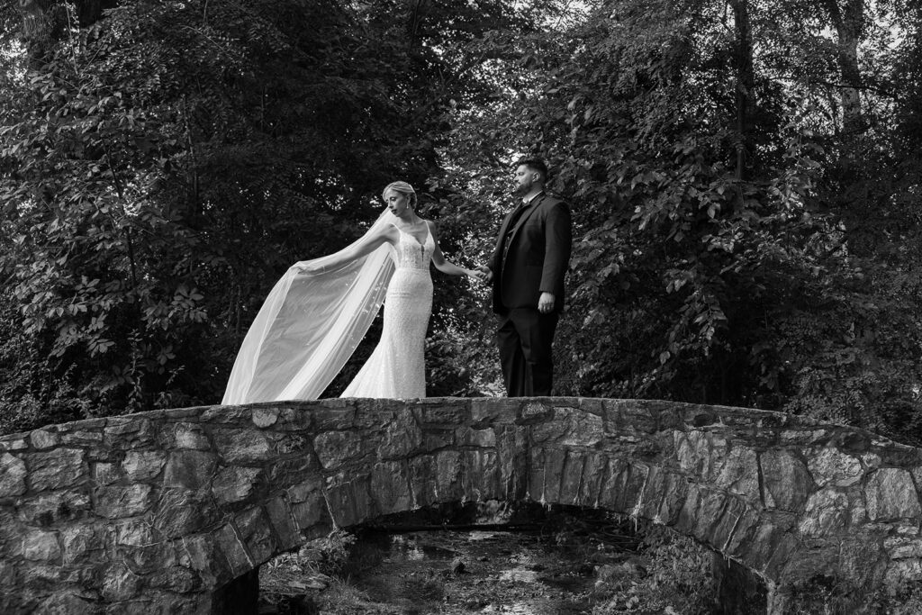 bride and groom pose on bridge at Cameron Estate Inn Wedding