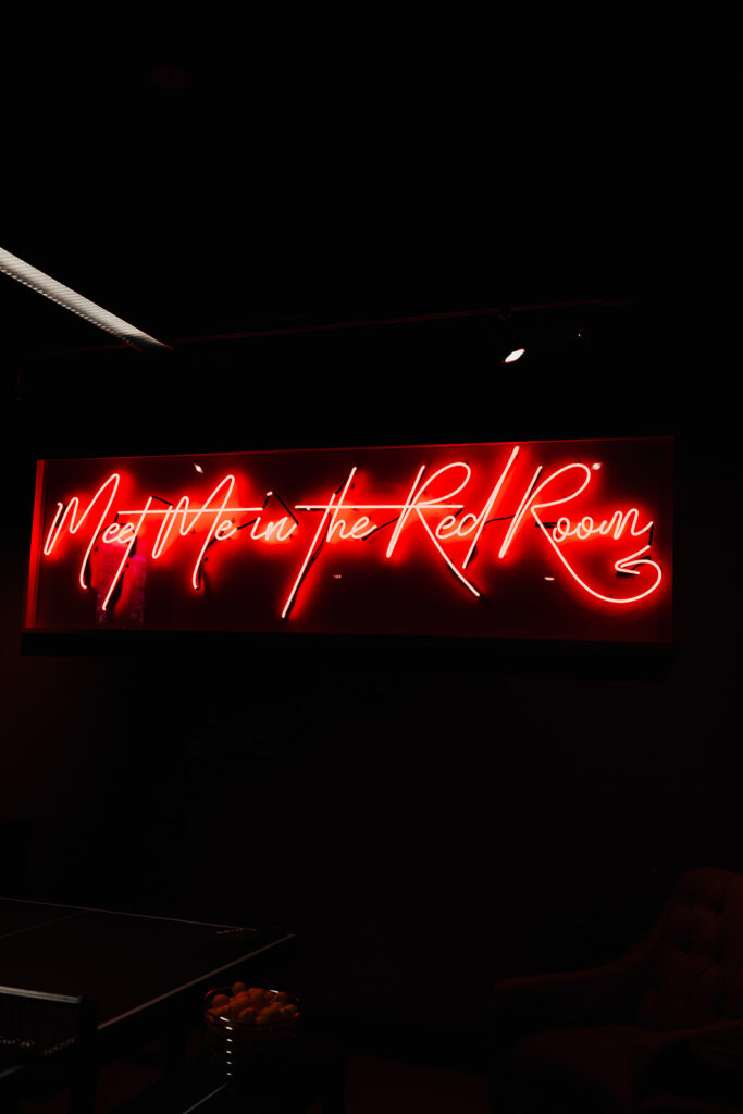 neon light at SPIN that says "meet me in the red room"