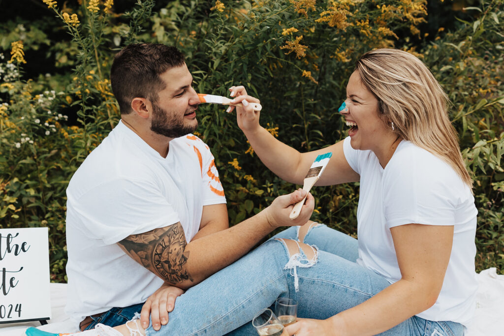 couple having a painting date at their outdoor engagement photos