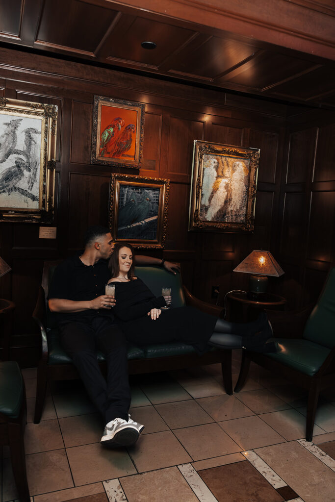 Couple enjoying an evening engagement session at The Hamilton lounge bar in Washington DC, sharing intimate moments in a warm, ambient setting.