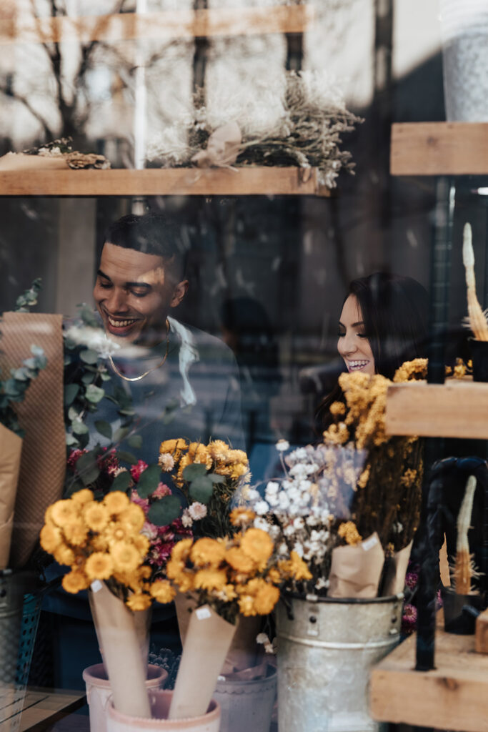 Couple enjoying a coffee date during their engagement session in Washington DC, sharing smiles and warm mugs in a cozy café setting.