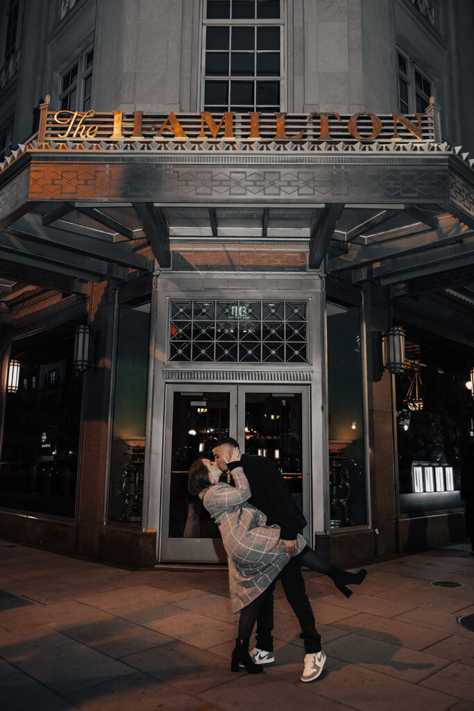 Couple enjoying an evening engagement session at The Hamilton lounge bar in Washington DC, sharing intimate moments in a warm, ambient setting.