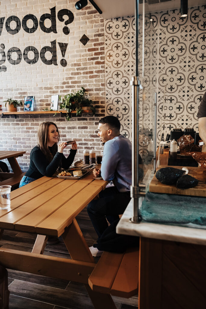 Couple enjoying a coffee date during their engagement session in Washington DC, sharing smiles and warm mugs in a cozy café setting.