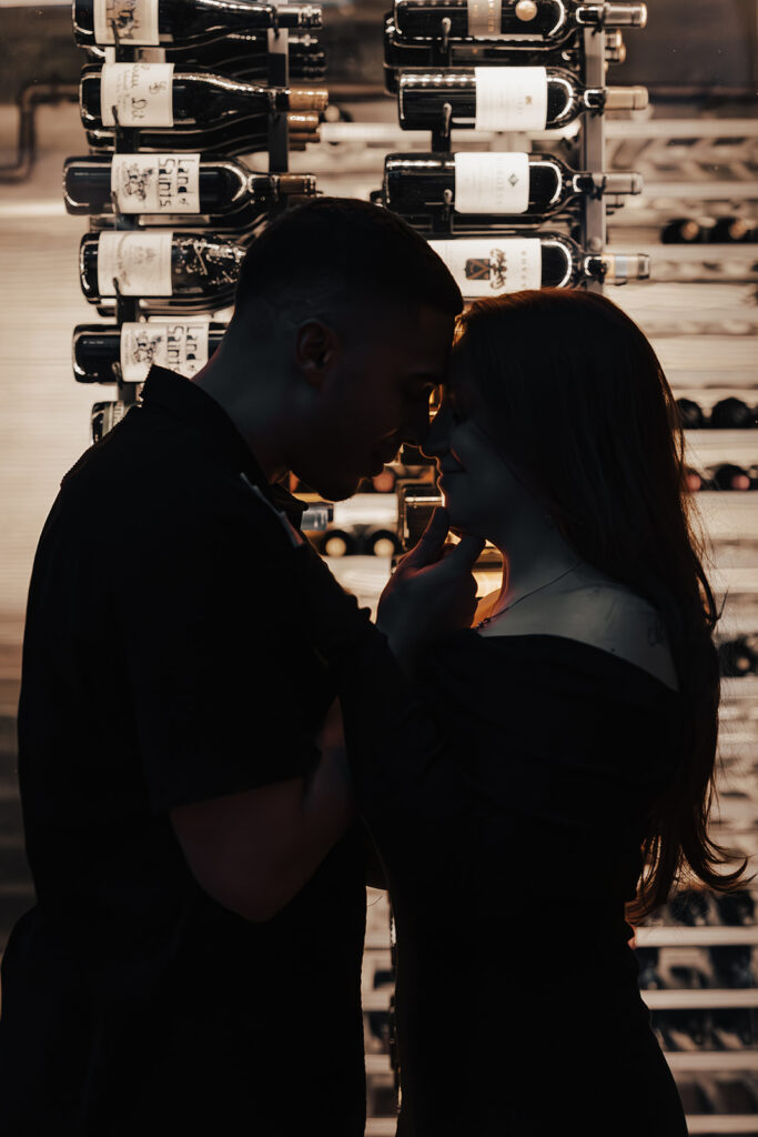 Couple enjoying an evening engagement session at The Hamilton lounge bar in Washington DC, sharing intimate moments in a warm, ambient setting.